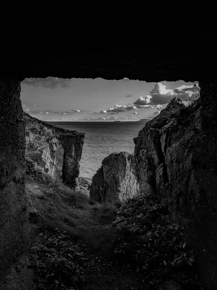 pexels-photo-3458700 Black and white landscape of a cave overlooking the ocean and cliffs.